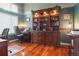 Home office with built-in bookshelves, a spacious desk, and hardwood floors at 16158 Whitestone Dr, Parker, CO 80134