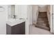 Modern bathroom with sleek sink and cabinet, next to stairs and white door at 1299 Osceola St, Denver, CO 80204