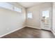 Bright bedroom with hardwood floors, two windows, and glass door leading to a balcony at 1299 Osceola St, Denver, CO 80204