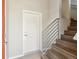 Bright entryway featuring hardwood stairs with metal railing and a white door at 1299 Osceola St, Denver, CO 80204