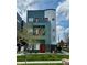 Modern three-story home with gray and blue facade, red door, and small front yard at 1299 Osceola St, Denver, CO 80204