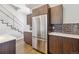 Bright kitchen featuring stainless steel refrigerator and sleek dark wood cabinets at 1299 Osceola St, Denver, CO 80204