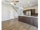 Open living room next to kitchen with hardwood floors, ceiling fan, and staircase at 1299 Osceola St, Denver, CO 80204