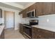 Kitchen view showcasing stainless steel appliances, granite countertops, and wooden cabinets at 814 N Bently St, Watkins, CO 80137