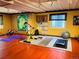 Home gym in the basement features yellow walls, fitness equipment, and a cozy workout space at 4307 Lily Gulch Trl, Castle Rock, CO 80109