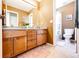 Bathroom featuring double sinks, wood cabinets, tile floor, and bathtub shower at 4307 Lily Gulch Trl, Castle Rock, CO 80109