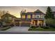 Charming two-story home with a stone facade, inviting front porch, and lush landscaping at sunset at 4307 Lily Gulch Trl, Castle Rock, CO 80109