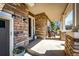 Charming covered front porch with stone facade, seating, and manicured landscaping at 4307 Lily Gulch Trl, Castle Rock, CO 80109