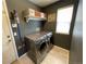 Functional laundry room with modern washer and dryer, storage shelves, and good lighting at 4307 Lily Gulch Trl, Castle Rock, CO 80109