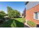 Backyard featuring a lush lawn, mature trees, and a brick exterior at 3259 W 111Th Drive, Westminster, CO 80031