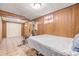 Basement featuring paneled walls, tile floor, bed, and workout equipment at 5070 W 66Th Ave, Arvada, CO 80003