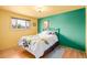 Bright bedroom with yellow and green accent wall and hardwood floors at 5070 W 66Th Ave, Arvada, CO 80003