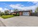 Charming brick home with a well-maintained front yard, mature bushes, and an attached garage at 5070 W 66Th Ave, Arvada, CO 80003