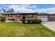 Charming brick home with a well-maintained front yard, lush green lawn, and a two-car garage at 5070 W 66Th Ave, Arvada, CO 80003