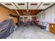 Garage featuring open ceiling, storage cabinets, lawn mowers, and bicycles at 5070 W 66Th Ave, Arvada, CO 80003