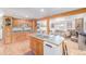 Open kitchen featuring wood cabinets, a center island with a sink, and hardwood floors at 5070 W 66Th Ave, Arvada, CO 80003