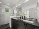 Modern bathroom featuring double vanity, sleek black countertops, and a glass-enclosed shower with window at 3715 Kalamath St, Denver, CO 80211