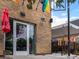 Exterior of Fox and the Hen brick building with rainbow flag and sidewalk patio with tent at 3715 Kalamath St, Denver, CO 80211