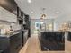 Stylish black kitchen featuring a large island, modern appliances, and sleek cabinetry at 3715 Kalamath St, Denver, CO 80211