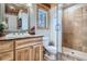 Well-lit bathroom featuring stylish vanity, framed mirror, and glass-enclosed shower with tile surround at 9659 S Turkey Creek Rd, Morrison, CO 80465