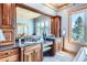 Main bathroom vanity with double sinks, granite countertop, wood cabinets, decorative mirror, and recessed lighting at 9659 S Turkey Creek Rd, Morrison, CO 80465
