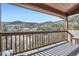 A covered wooden deck features panoramic mountain views beyond the railing at 9659 S Turkey Creek Rd, Morrison, CO 80465