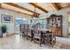 Elegant dining room with a long wooden table, a decorative chandelier, and large windows with scenic views at 9659 S Turkey Creek Rd, Morrison, CO 80465