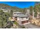A stunning two-story house on a hillside, featuring a balcony and a two-car garage at 9659 S Turkey Creek Rd, Morrison, CO 80465