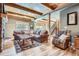 Spacious living room with a stone fireplace, wood beams, and hardwood floors at 9659 S Turkey Creek Rd, Morrison, CO 80465