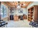 Spacious office features wood accents, a ceiling fan, large windows, built-in shelves, and ample space for working and relaxing at 9659 S Turkey Creek Rd, Morrison, CO 80465