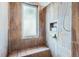 Walk-in shower featuring elegant tile work, a built-in bench, soap niche and a frosted glass window at 9659 S Turkey Creek Rd, Morrison, CO 80465