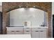Close-up of kitchen with cooktop, patterned tile, and brick arch at 8090 Newton St, Westminster, CO 80031