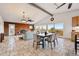 Open-concept living and dining area featuring exposed brick fireplace, large windows, and tile floors at 8090 Newton St, Westminster, CO 80031