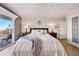 Bedroom with hardwood floors, ceiling fan, slider to balcony, bedside tables, and wall decor at 8090 Newton St, Westminster, CO 80031