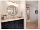 Bathroom featuring a round mirror, granite countertop, navy blue cabinets, and gold hardware at 4711 S Logan St, Englewood, CO 80113