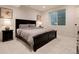 Serene bedroom with a dark bed frame, soft carpet, and a bright window at 4711 S Logan St, Englewood, CO 80113