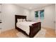Bedroom with a large bed, wood headboard, light hardwood floors, and a window overlooking the backyard at 4711 S Logan St, Englewood, CO 80113