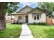 Charming home featuring a well-manicured lawn, cozy porch, and stone walkway at 4711 S Logan St, Englewood, CO 80113