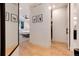 Hallway with light hardwood floors leading into a bedroom with a ceiling fan and bench at the foot of the bed at 4711 S Logan St, Englewood, CO 80113