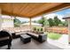 Covered outdoor patio with comfortable seating, a grill, and a view of the landscaped backyard at 4711 S Logan St, Englewood, CO 80113