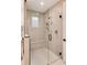 Shower with glass enclosure, shower seat, brushed gold shower head and hand shower, and a small window at 4711 S Logan St, Englewood, CO 80113