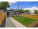 Well-maintained backyard with a wooden fence, green grass, and gravel path at 2521 N Gaylord St, Denver, CO 80205