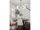 Dining space with a round table, modern lighting fixture, and view into the living room and staircase at 2521 N Gaylord St, Denver, CO 80205