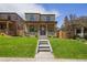 Exterior view of brick home with a covered porch and well-kept lawn leading to a welcoming entrance at 2521 N Gaylord St, Denver, CO 80205