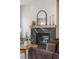 Close-up of a modern black marble fireplace with wood mantel and decorative accents at 2521 N Gaylord St, Denver, CO 80205