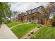 Street view of newly built brick home featuring a well-manicured lawn and covered front porch at 2521 N Gaylord St, Denver, CO 80205