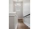 Modern staircase with hardwood steps, white risers, a black handrail, and a stylish chandelier at 2521 N Gaylord St, Denver, CO 80205