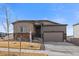 Charming single Gathering house showcasing stone accents, a two-car garage, well maintained lawn, and an inviting front porch at 18001 Herrera Dr, Parker, CO 80134