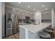 Modern kitchen with stainless steel appliances, gray cabinetry, a center island with breakfast bar seating, and wood floors at 18001 Herrera Dr, Parker, CO 80134