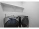 Modern laundry room with Whirlpool washer and dryer, and convenient shelving for storage at 18001 Herrera Dr, Parker, CO 80134